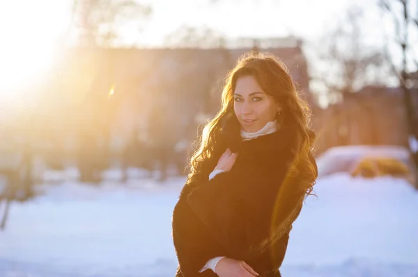 Schöne junge Frau im Pelzmantel geht durch die Winterstraße — Stockfoto
