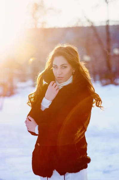 Schöne junge Frau im Pelzmantel geht durch die Winterstraße — Stockfoto