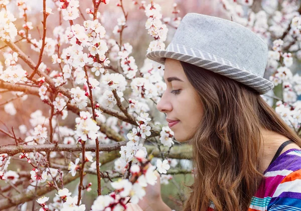 Mladá žena vonící třešňový květ — Stock fotografie