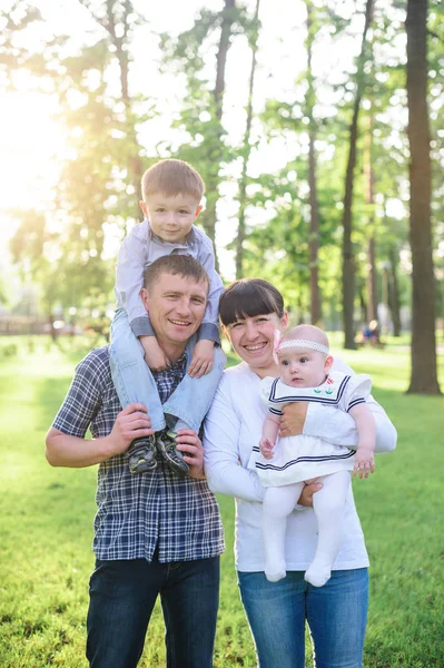 Young parents with children walk in the summer park — Stock Photo, Image