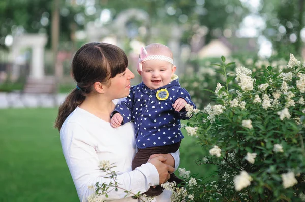 Maminka a malé dcerušky procházky v parku na jaře — Stock fotografie