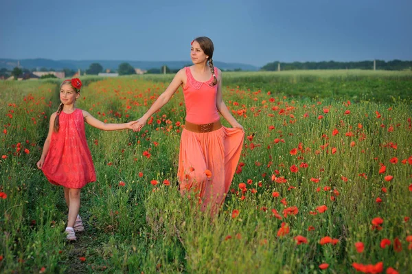 Haşhaş sahada yürüyüş anne ile küçük kız — Stok fotoğraf