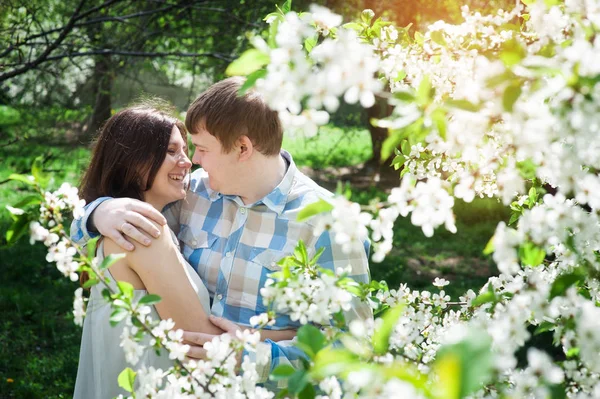 Jovem casal amoroso andando em um jardim de primavera — Fotografia de Stock