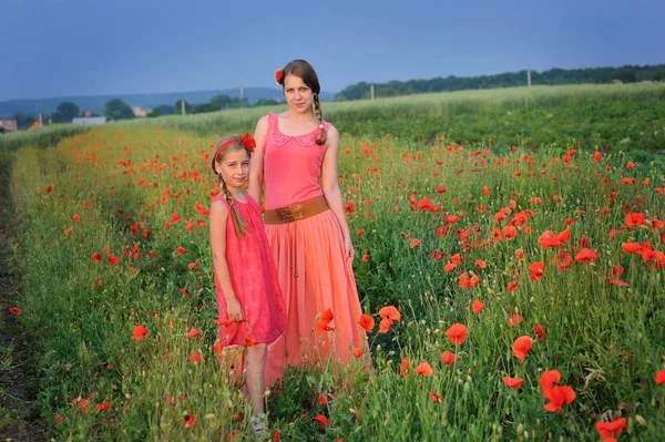 Niña con madre caminando en el campo de amapola — Foto de Stock