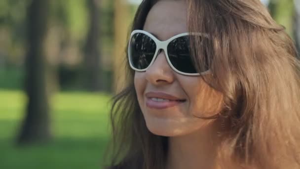 Ευτυχισμένος νεαρή γυναίκα σε γυαλιά ηλίου στο πάρκο καλοκαίρι — Αρχείο Βίντεο