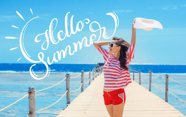 Büyük beyaz şapka ve metin Merhaba yaz iskelede duran mutlu kadın. Hat yazı — Stok fotoğraf