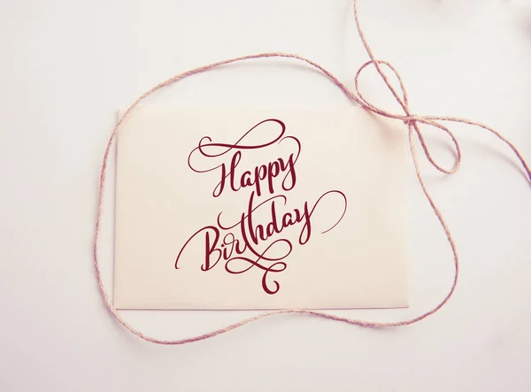 Sheet of paper with bow and text Happy Birthday. Calligraphy lettering. Greating card — Stock Photo, Image