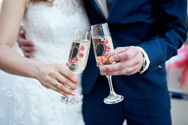 Bride and groom are holding champagne glasses — Stock Photo, Image