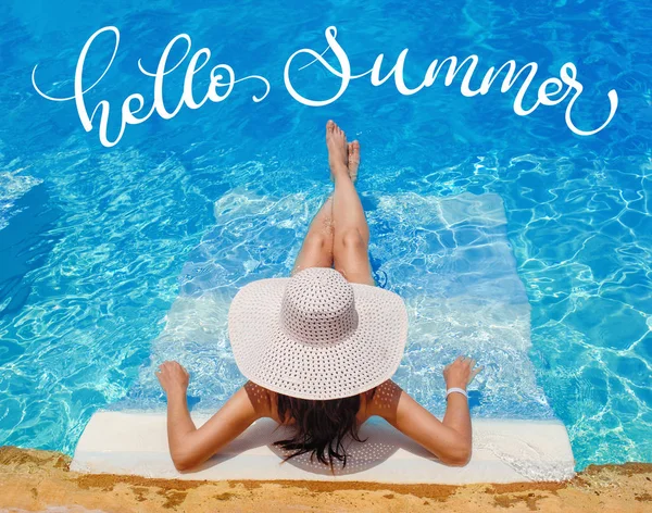 Kobieta w wielkim kapeluszu leżąc na leżaku przy basenie i tekst Hello lato, kaligrafia napis — Zdjęcie stockowe