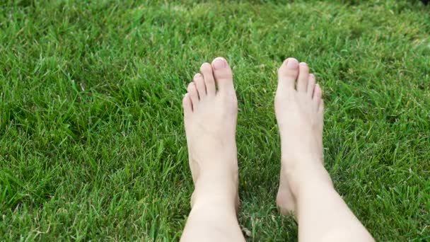 Женские ноги на зеленой траве в парке — стоковое видео