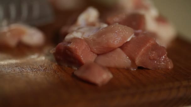 Chef-kok snijdt vlees op een houten bord met een mes — Stockvideo