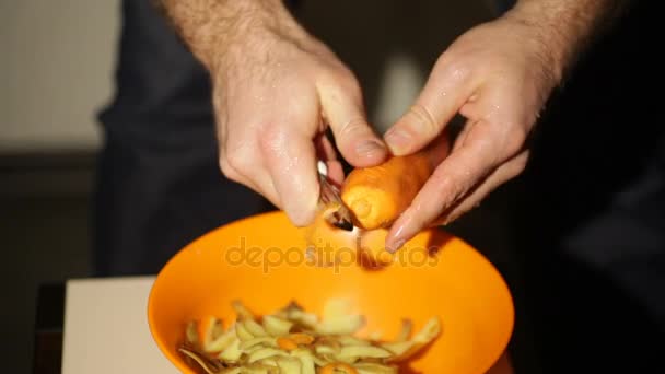 Шеф-кухар очищає моркву на кухні — стокове відео