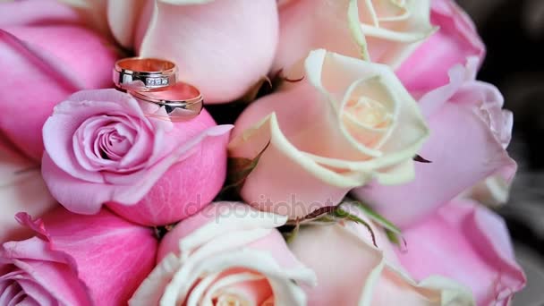 Two gold rings on a bouquet of the bride — Stock Video