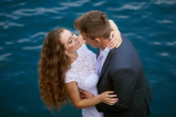 Joven pareja amorosa en un paseo cerca del lago en el día de su boda —  Fotos de Stock