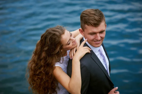 Joven pareja amorosa en un paseo cerca del lago en el día de su boda —  Fotos de Stock