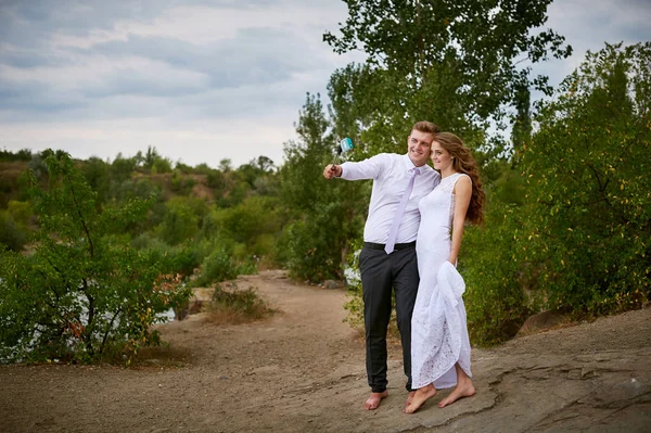 Bride and groom on a wedding walk take selfie — Stock Photo, Image