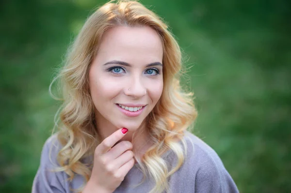 Eine schöne junge Frau im Sommerpark posiert — Stockfoto
