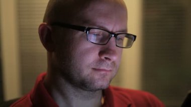 ofiste onun elinde bir tablet ile gözlüklü adam oturur