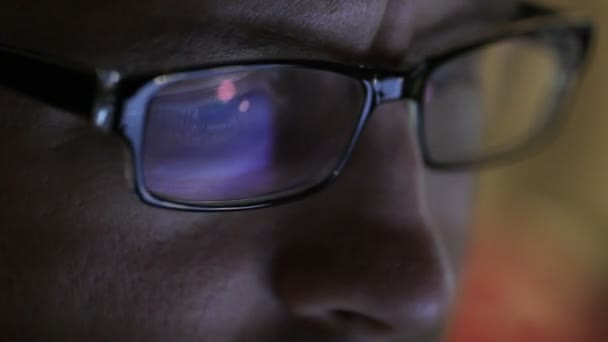 Людина в окулярах сидить з таблеткою в руках в офісі — стокове відео