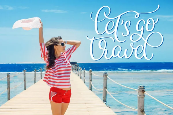 Mujer feliz de pie en el muelle con gran sombrero blanco y texto Vamos a viajar. Caligrafía letras mano dibujar — Foto de Stock