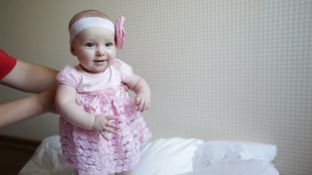 Mom learns to walk a little baby girl in a pink dress — Stock Video