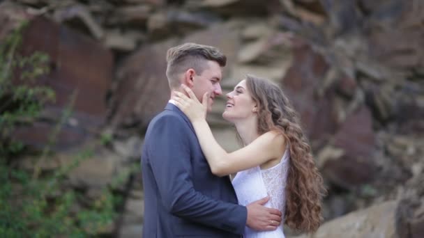 Sposa e sposo abbracciare su una passeggiata nuziale sullo sfondo della montagna — Video Stock