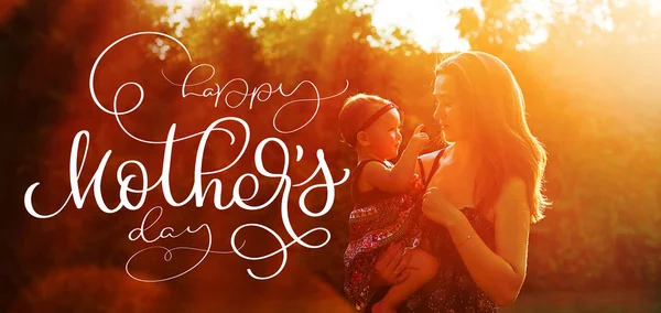 Счастливая молодая мама с дочкой и текстом Счастливый день матери. Рисунок руки с каллиграфией — стоковое фото
