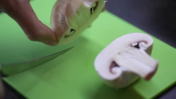 Женщина режет грибы на кухне — стоковое видео