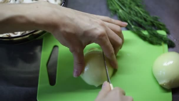 Vrouw plakjes een boog op een groen bord — Stockvideo