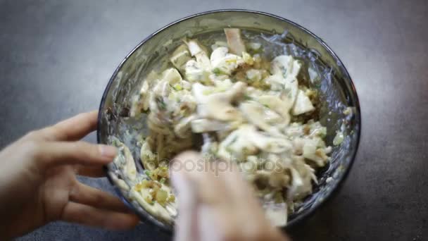 Vrouw een salade roeren in de schotel in de keuken — Stockvideo