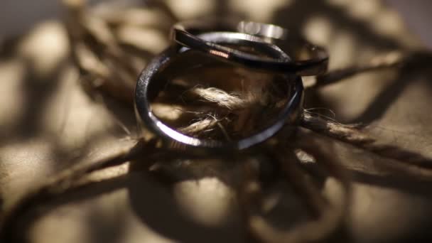 Dois anéis de ouro de casamento e silhuetas de estrelas — Vídeo de Stock