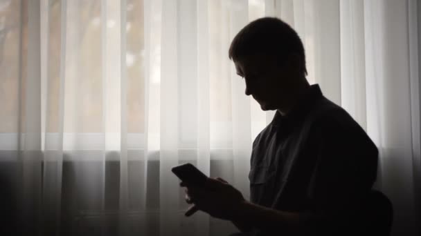 Silhouet van man met smartphone — Stockvideo