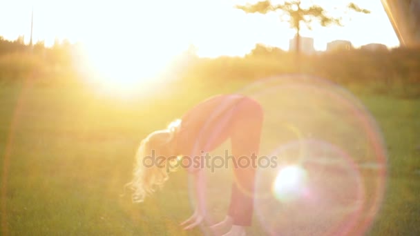 Ung kvinna gör yoga på gräs — Stockvideo