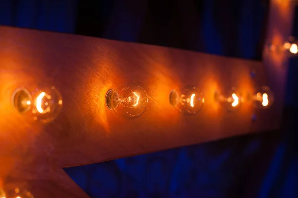Glödlampor på en trä bakgrund som en del av inredning — Stockfoto
