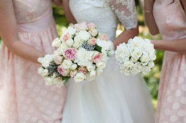 Gelin ve el buketleri ile onun nedime-pembe çiçekli düğün