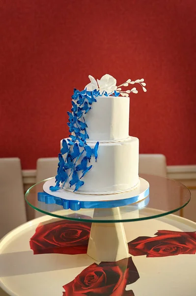 Blau-weiße Hochzeitstorte Nahaufnahme mit Braut und Bräutigam an der Spitze — Stockfoto