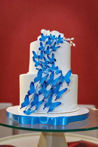 Gâteau de mariage à deux niveaux avec des papillons bleus — Photo