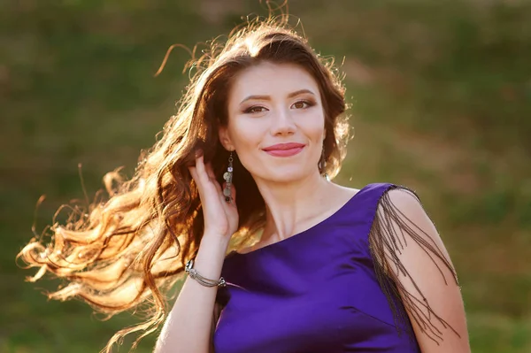 Retrato de una mujer feliz con el pelo rizado al aire libre al atardecer —  Fotos de Stock