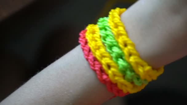 Тканые разноцветные браслеты на руке — стоковое видео