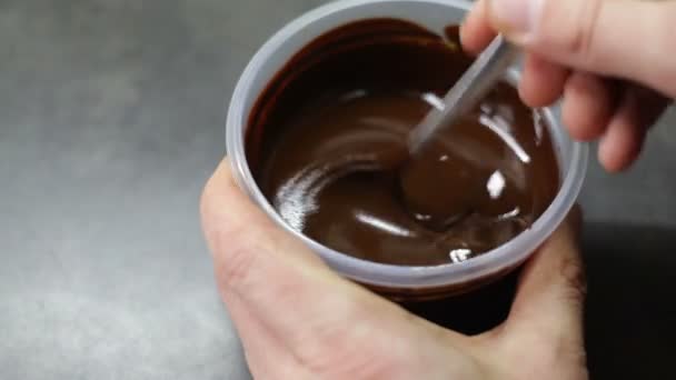Человек перемешивает горячий шоколад ложкой — стоковое видео