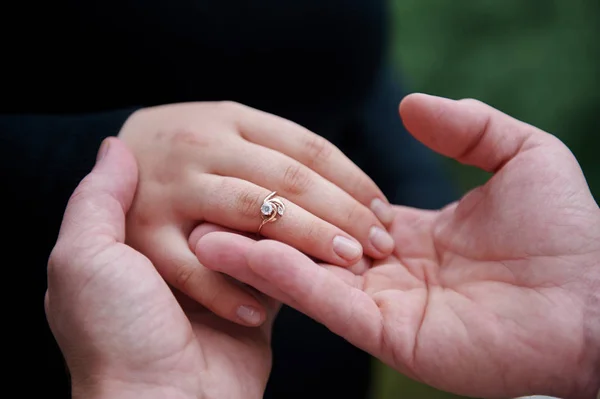 Człowiek ubiera pierścionek zaręczynowy na palcu kobiety — Zdjęcie stockowe