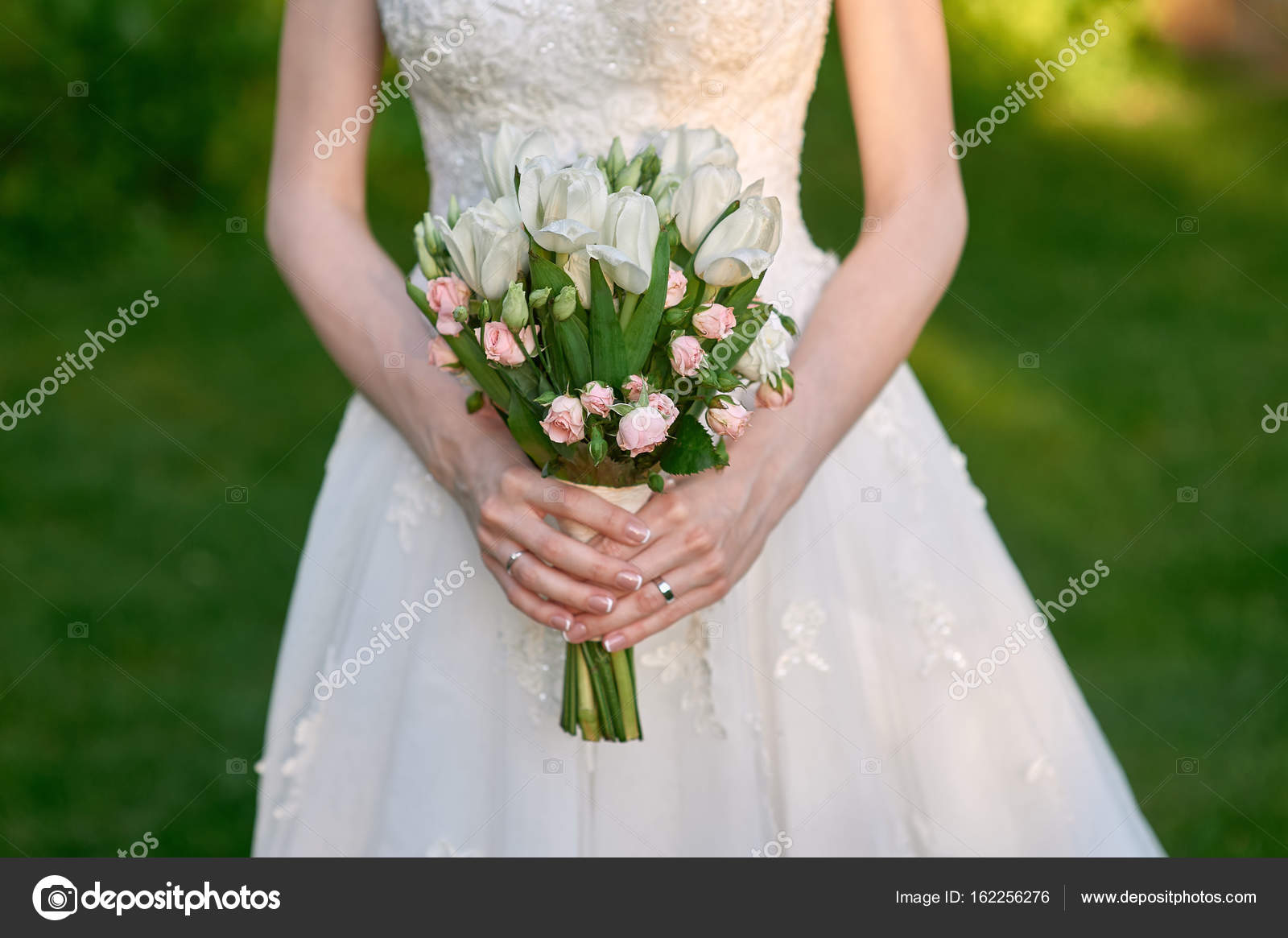Noiva está segurando um buquê de casamento de flores fotos, imagens de ©  timonko #162256276