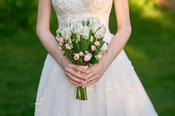 Noiva está segurando um buquê de casamento de flores — Fotografia de Stock