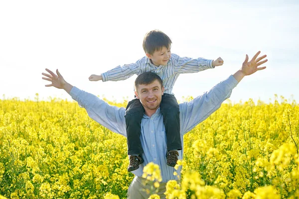 Babası küçük bir oğlu onun omuzlarında tutar.