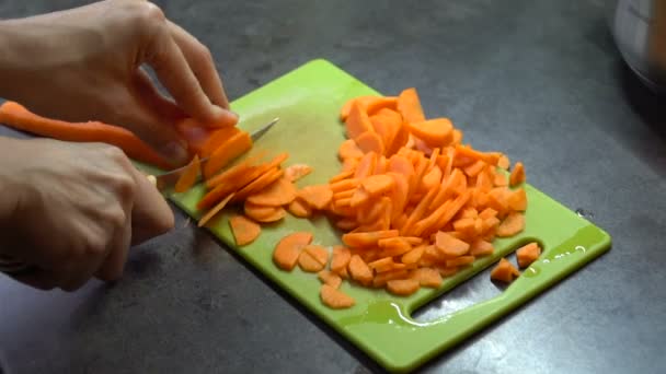 Kok snijdt de wortelen op het bord — Stockvideo