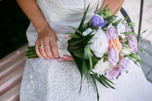 Mariée tient un bouquet de fleurs de mariage — Photo