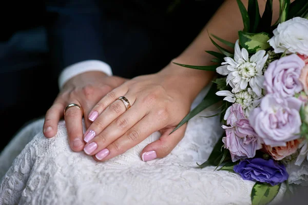 Mani della sposa e dello sposo vicino al bouquet di nozze per una passeggiata — Foto Stock