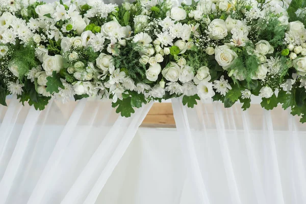 Decor of white flowers on the wedding arch