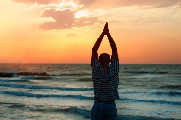 Silhouette eines Mannes macht Yoga bei Sonnenuntergang — Stockfoto