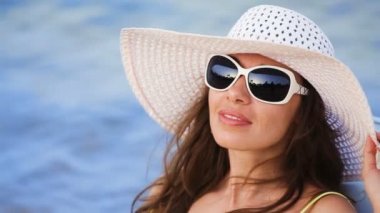 denize karşı sahilde güneşlenirken gözlük güzel genç kadın